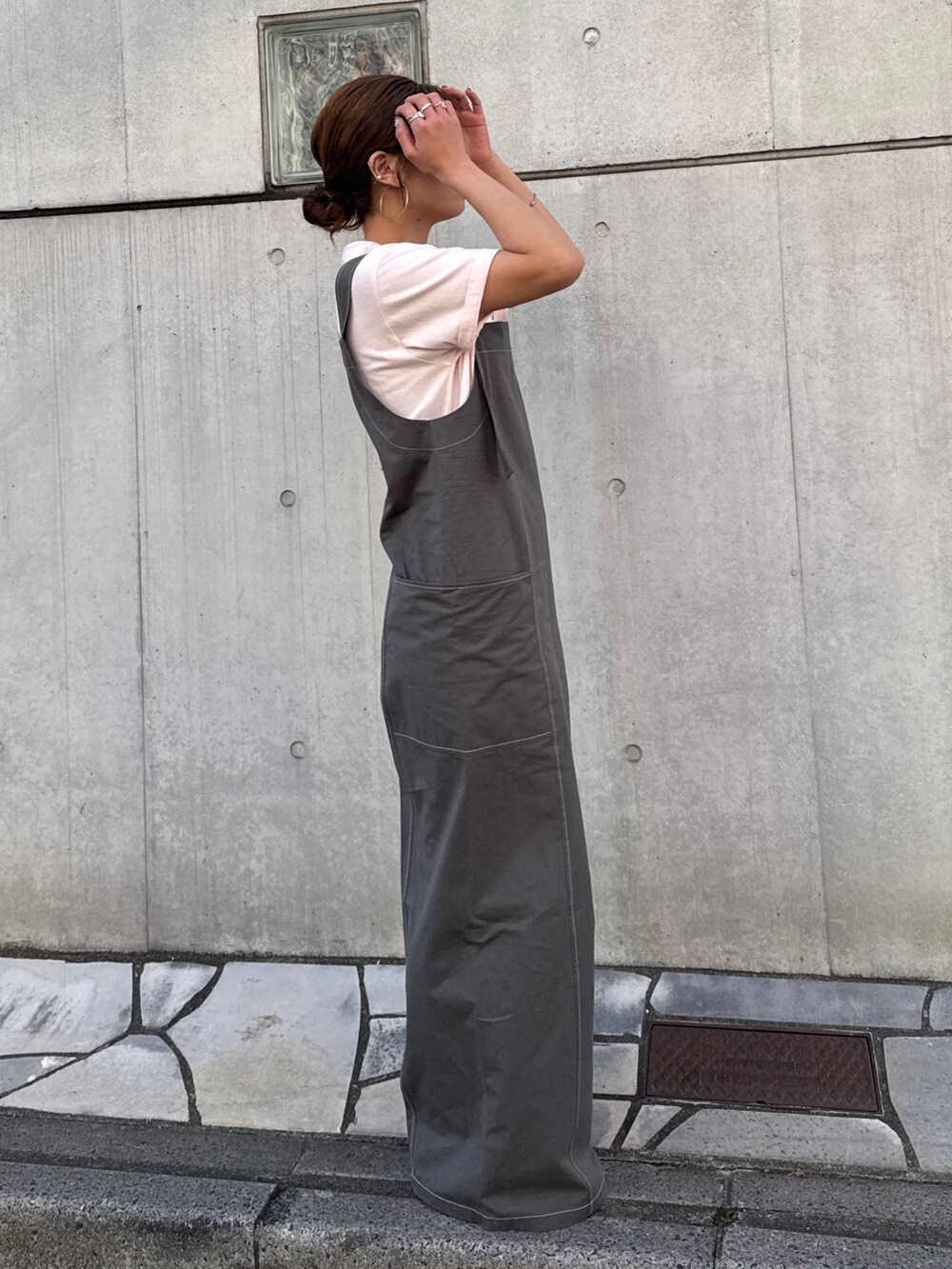 ピンク系のTシャツ/カットソー、ブラック系のサロペット/オーバーオール、ブラック系のサンダルを着用したレディースの春コーディネートの3枚目の写真