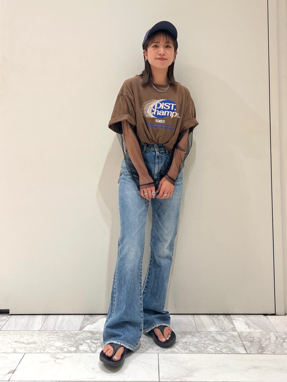ブラウン系のTシャツ/カットソー、ブラック系のTシャツ/カットソー、ブルー系のデニムパンツを着用したレディースの夏コーディネートの3枚目の写真