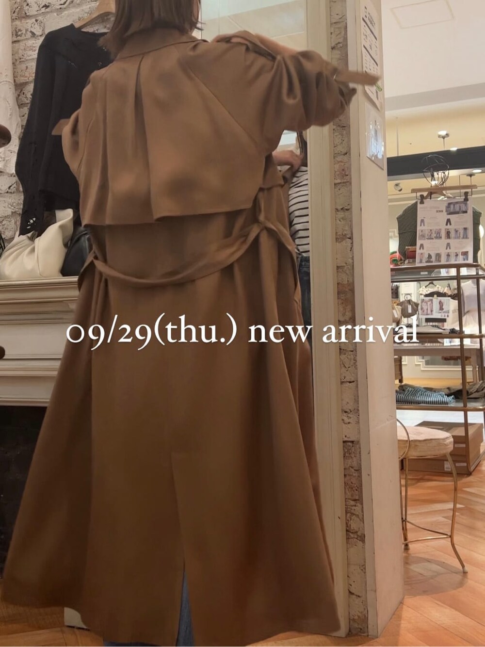 ブルー系のTシャツ/カットソー、イエロー系のトレンチコート、ホワイト系のブーツを着用したレディースの秋コーディネートの4枚目の写真