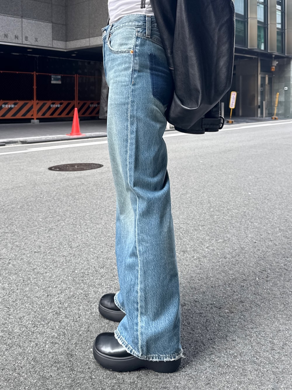 ブラック系のブルゾン、ブルー系のデニムパンツを着用したレディースの秋コーディネートの9枚目の写真