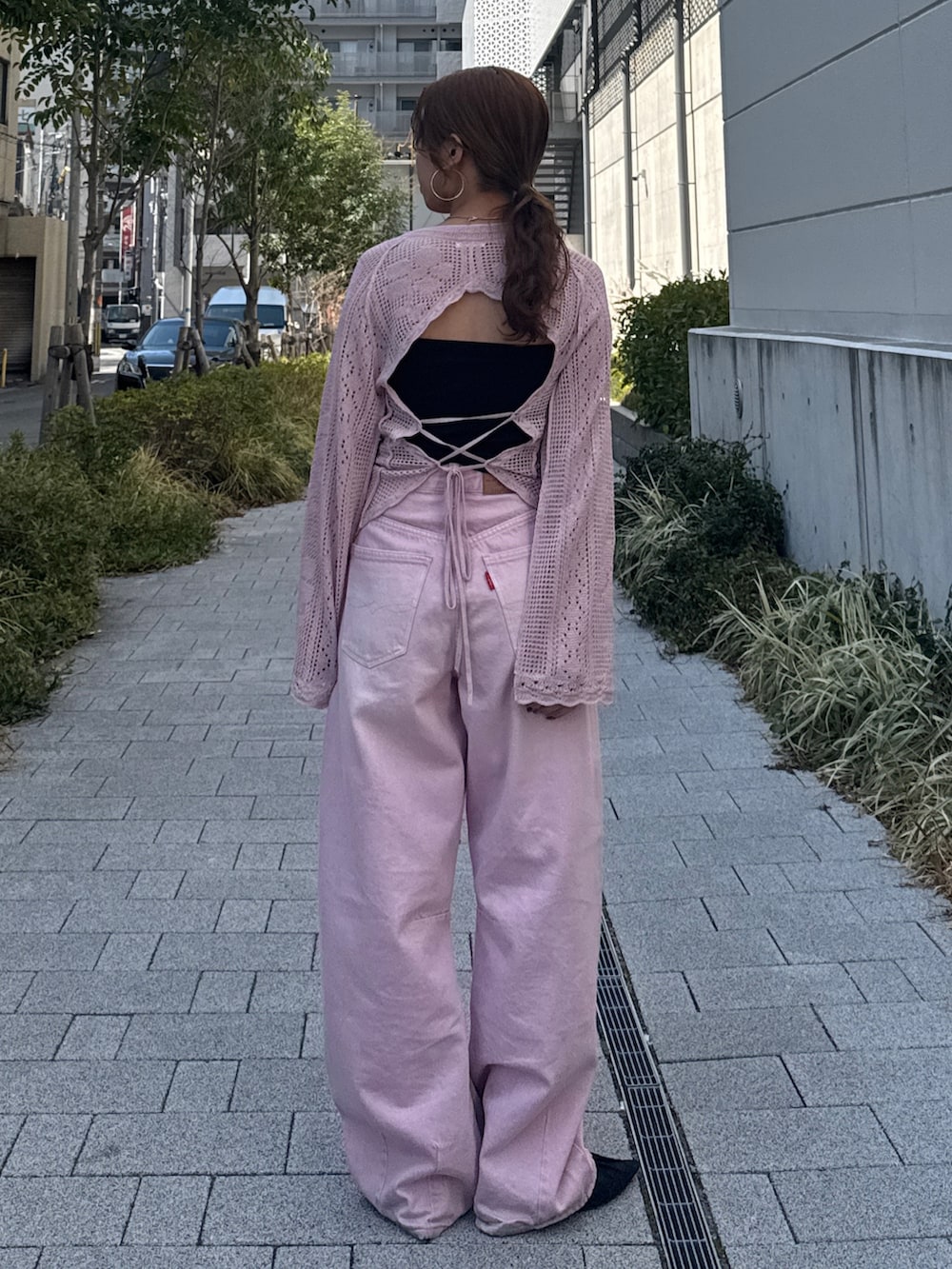 ピンク系のデニムパンツ、ピンク系のニット/セーター、ブラック系のパンプスを着用したレディースの春コーディネートの6枚目の写真