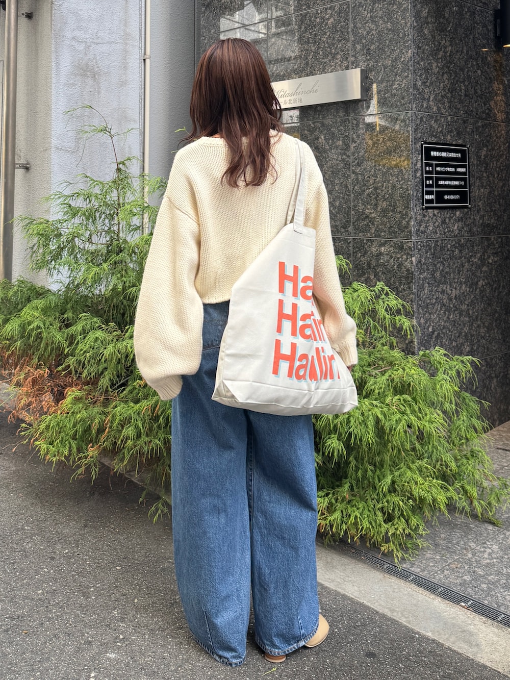 ブルー系のデニムパンツ、ホワイト系のニット/セーターを着用したレディースの秋コーディネートの5枚目の写真