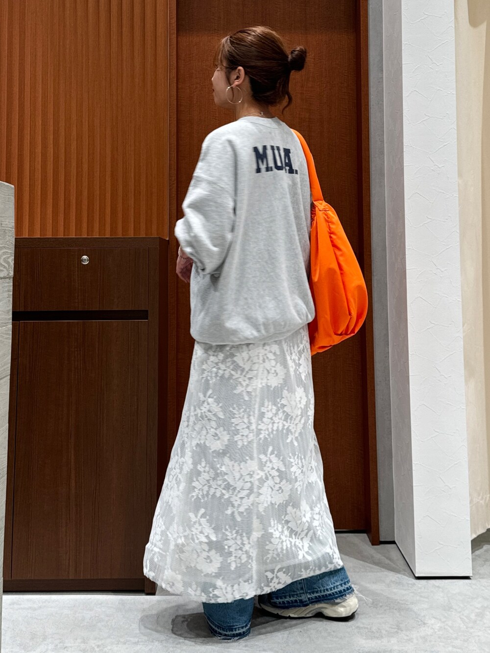 ホワイト系のワンピース、グレー系のスウェット、ブルー系のデニムパンツを着用したレディースの秋コーディネートの8枚目の写真