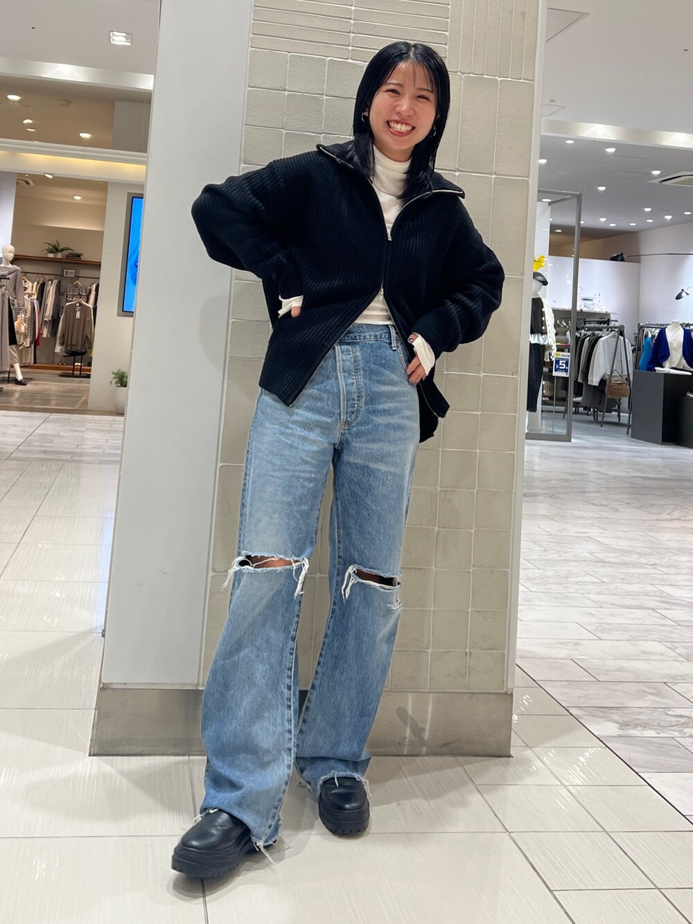 ブルー系のデニムパンツ、ブラック系のカーディガン/ボレロ、ホワイト系のTシャツ/カットソーを着用したレディースの秋コーディネートの5枚目の写真