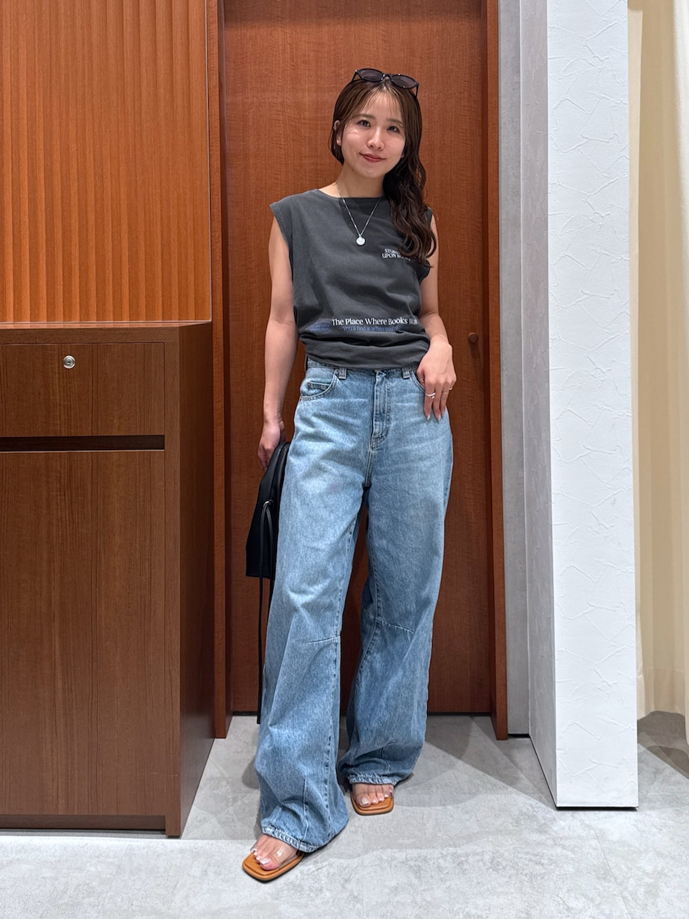 グレー系のタンクトップ、ブルー系のデニムパンツ、その他のサンダルを着用したレディースの夏コーディネートの6枚目の写真