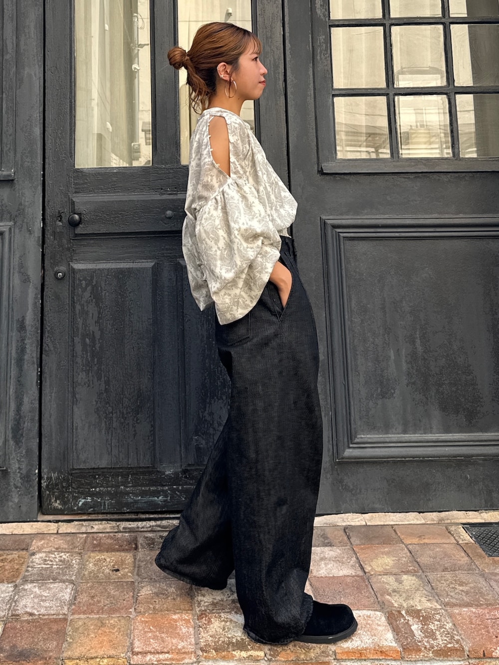 ブラック系のデニムパンツ、ブラック系のスリッポン、ホワイト系のシャツ/ブラウスを着用したレディースの秋コーディネートの4枚目の写真