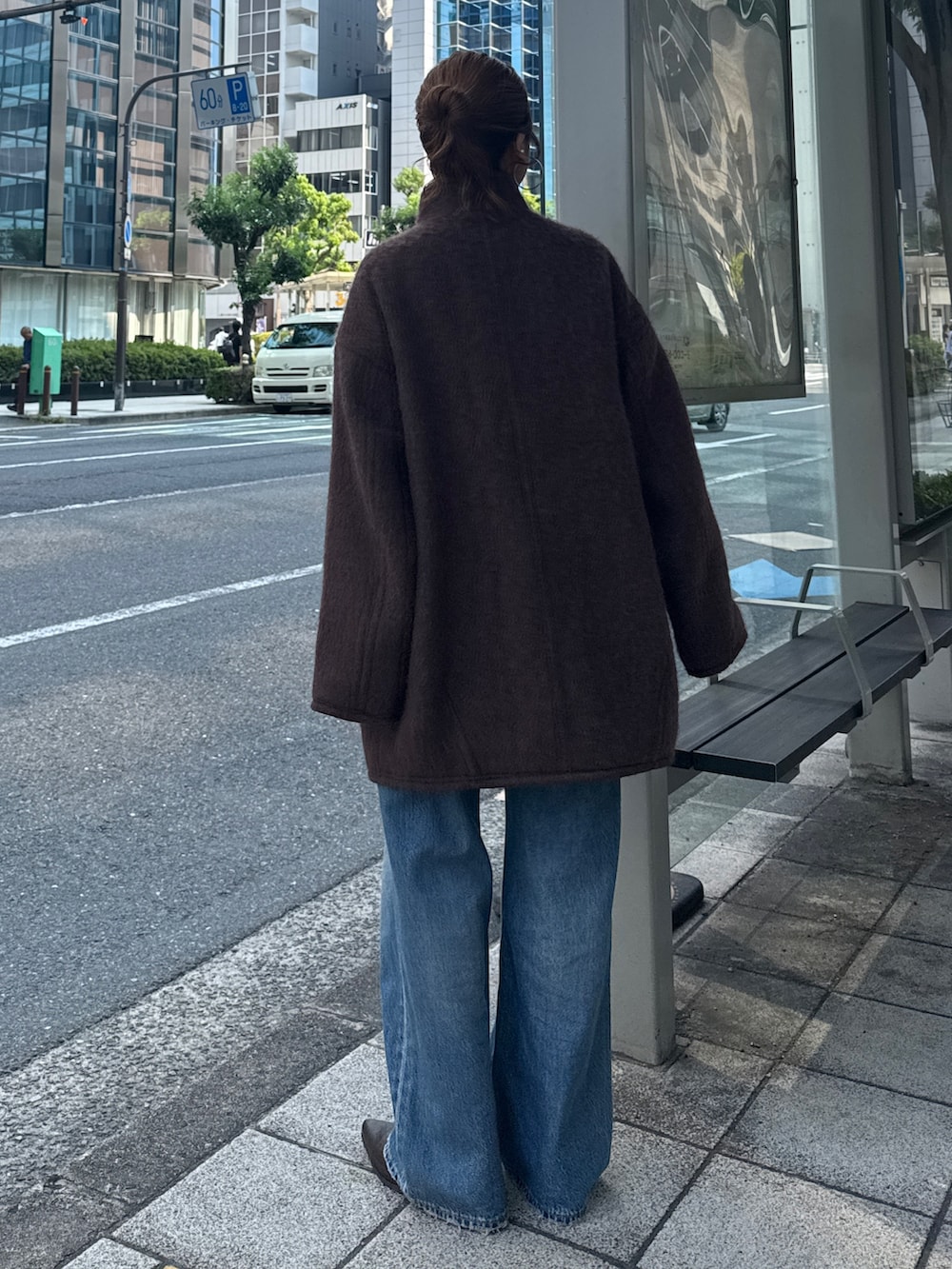 ブラウン系のダウンジャケット/コート、ブルー系のデニムパンツ、ブラウン系のブーツを着用したレディースの秋コーディネートの4枚目の写真