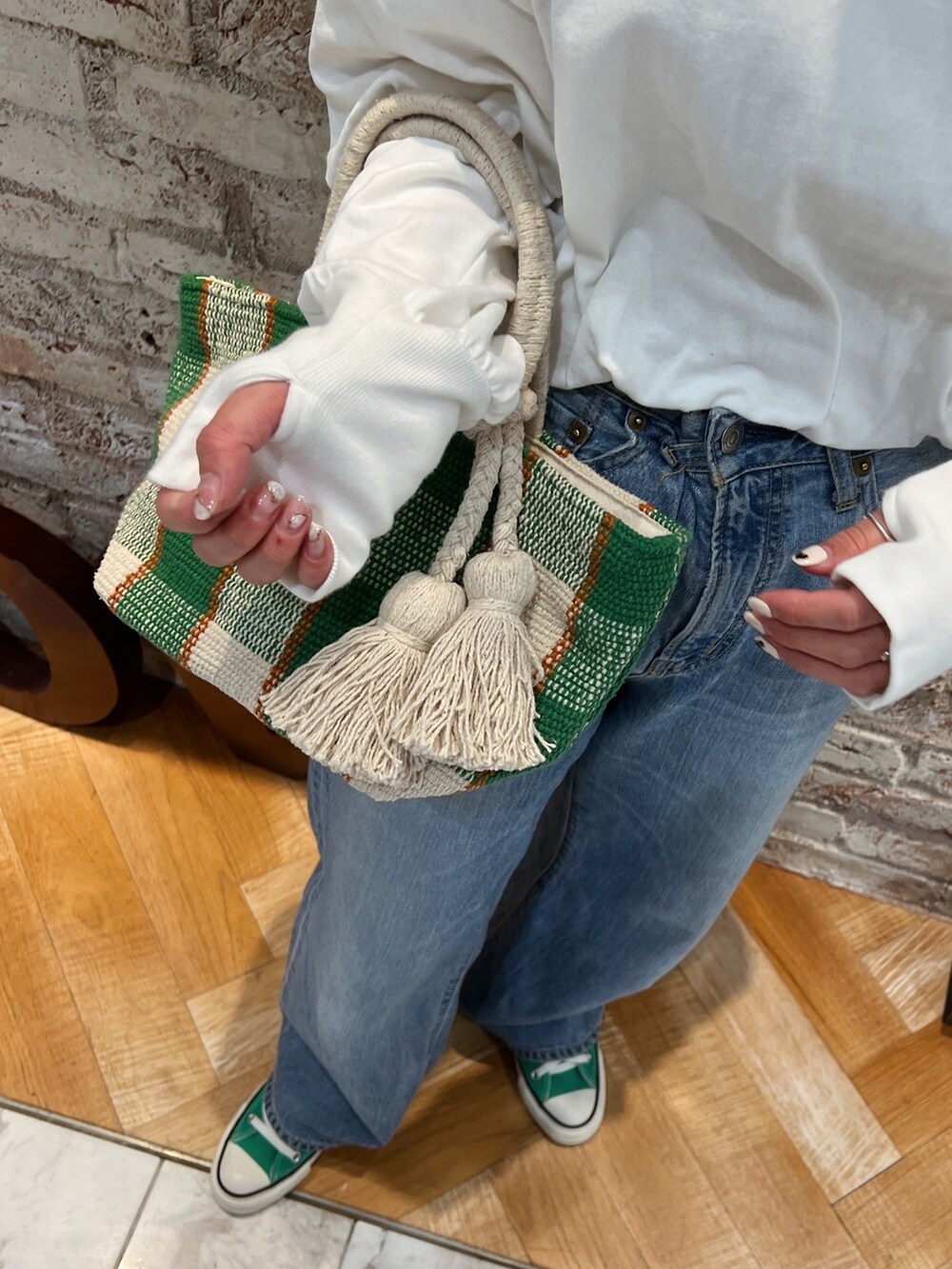 ブルー系のデニムパンツ、グリーン系のスニーカーを着用したレディースの春コーディネートの6枚目の写真
