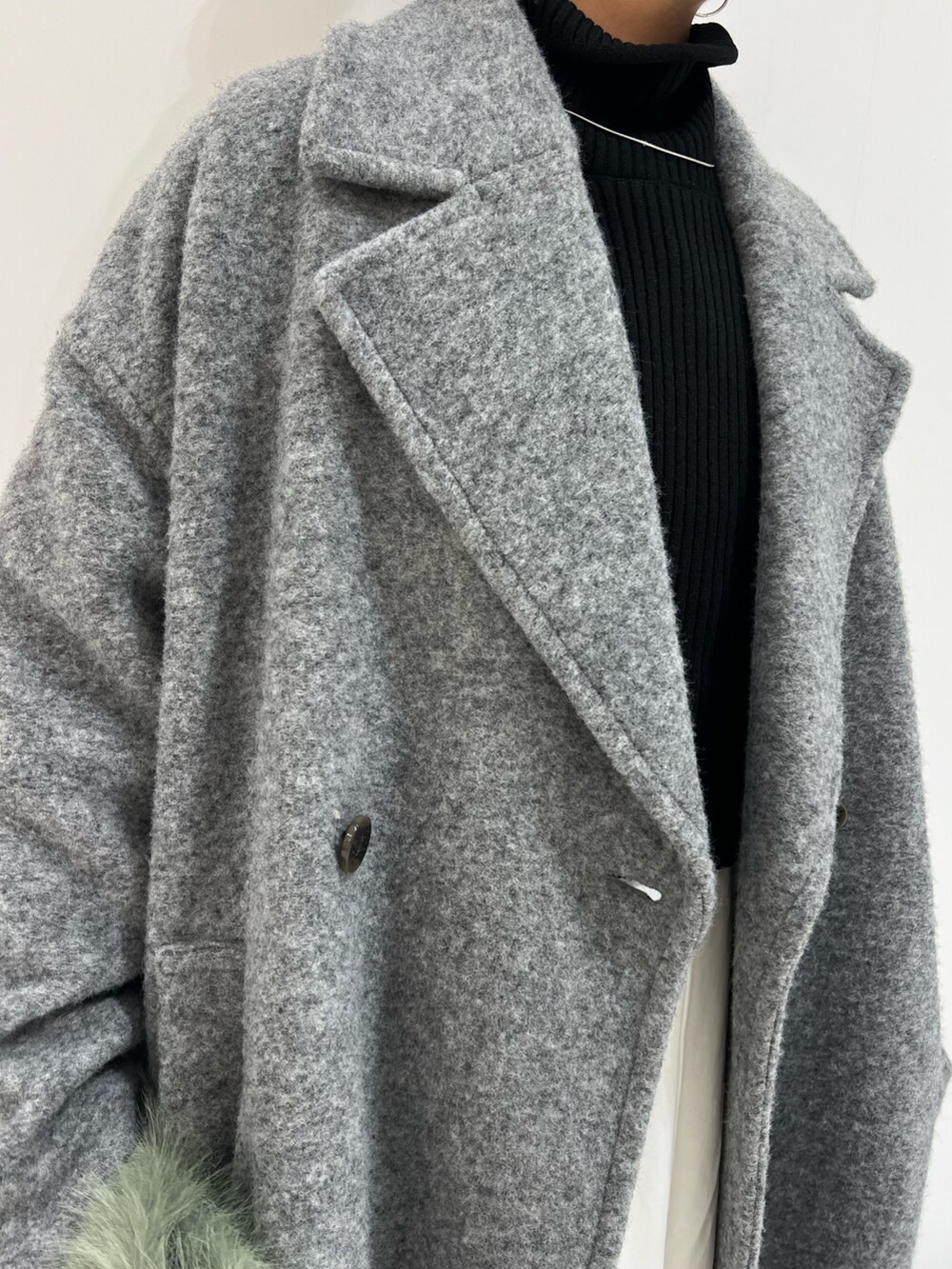 ブラウン系のブーツ、ブラック系のワンピース、グレー系のチェスターコートを着用したレディースの冬コーディネートの9枚目の写真