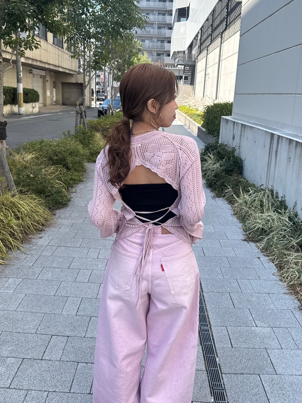 ピンク系のデニムパンツ、ピンク系のニット/セーター、ブラック系のパンプスを着用したレディースの春コーディネートの7枚目の写真