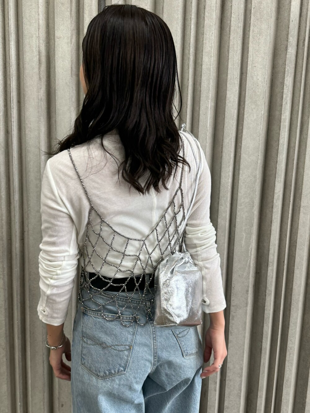 ブラック系のベスト、ブルー系のデニムパンツ、ホワイト系のTシャツ/カットソーを着用したレディースの冬コーディネートの10枚目の写真