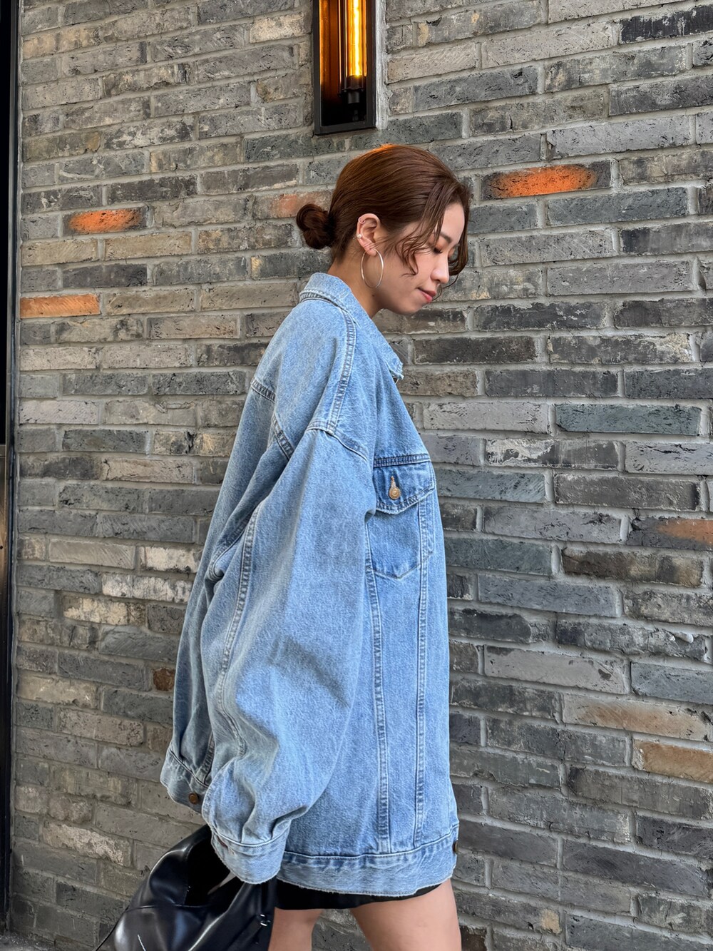 ブルー系のデニムジャケット、ブルー系のTシャツ/カットソー、ブラック系のその他パンツを着用したレディースの冬コーディネートの8枚目の写真