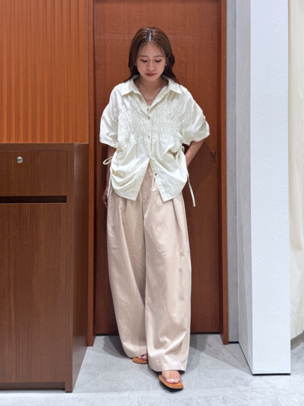 イエロー系のシャツ/ブラウス、その他のサンダル、ベージュ系のその他パンツを着用したレディースの夏コーディネートの2枚目の写真