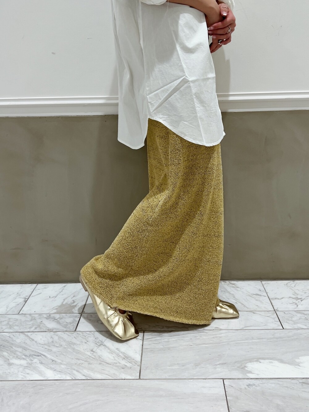 ホワイト系のシャツ/ブラウス、イエロー系のパンプス、ベージュ系のスカートを着用したレディースの冬コーディネートの5枚目の写真