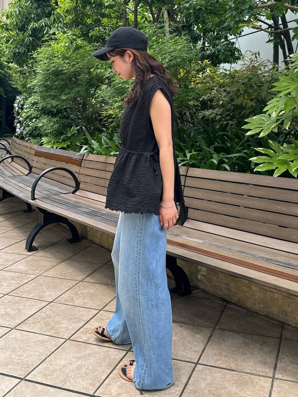 ブラック系のサンダル、ブルー系のデニムパンツ、ブラック系のシャツ/ブラウスを着用したレディースの夏コーディネートの6枚目の写真