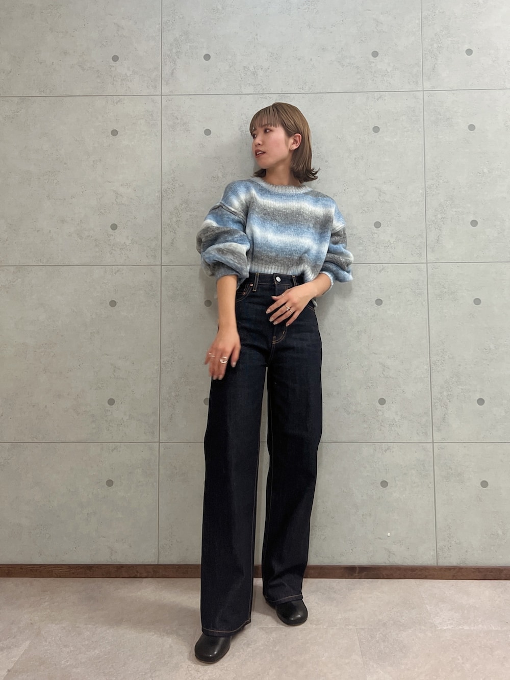 ブルー系のデニムパンツ、ブルー系のニット/セーターを着用したレディースの秋コーディネートの2枚目の写真