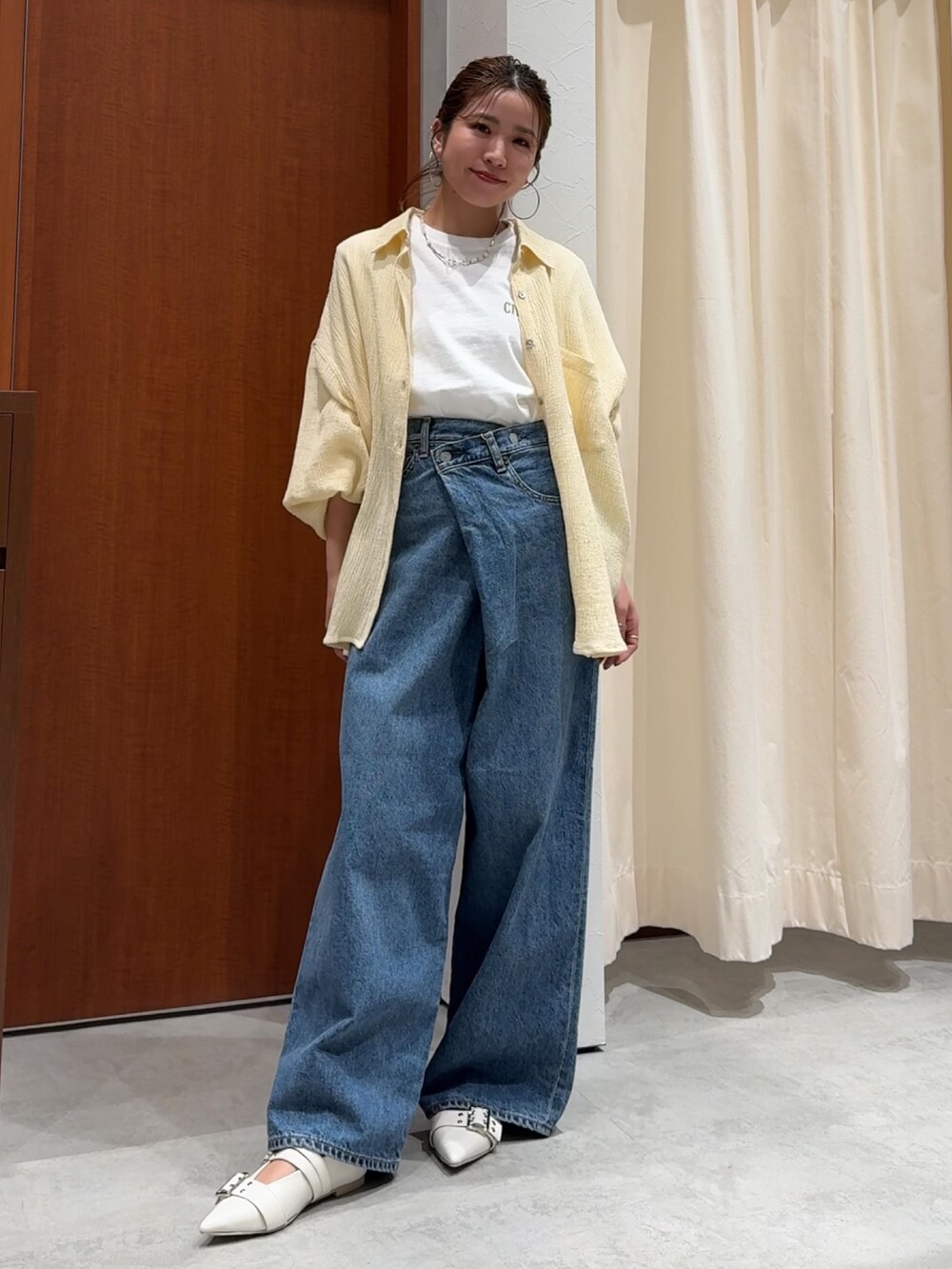 ブルー系のデニムパンツ、ホワイト系のTシャツ/カットソー、イエロー系のシャツ/ブラウスを着用したレディースの春コーディネートの2枚目の写真