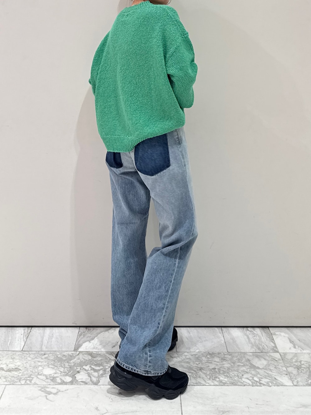 ブルー系のデニムパンツ、グリーン系のニット/セーター、シルバー系のネックレスを着用したレディースの冬コーディネートの6枚目の写真