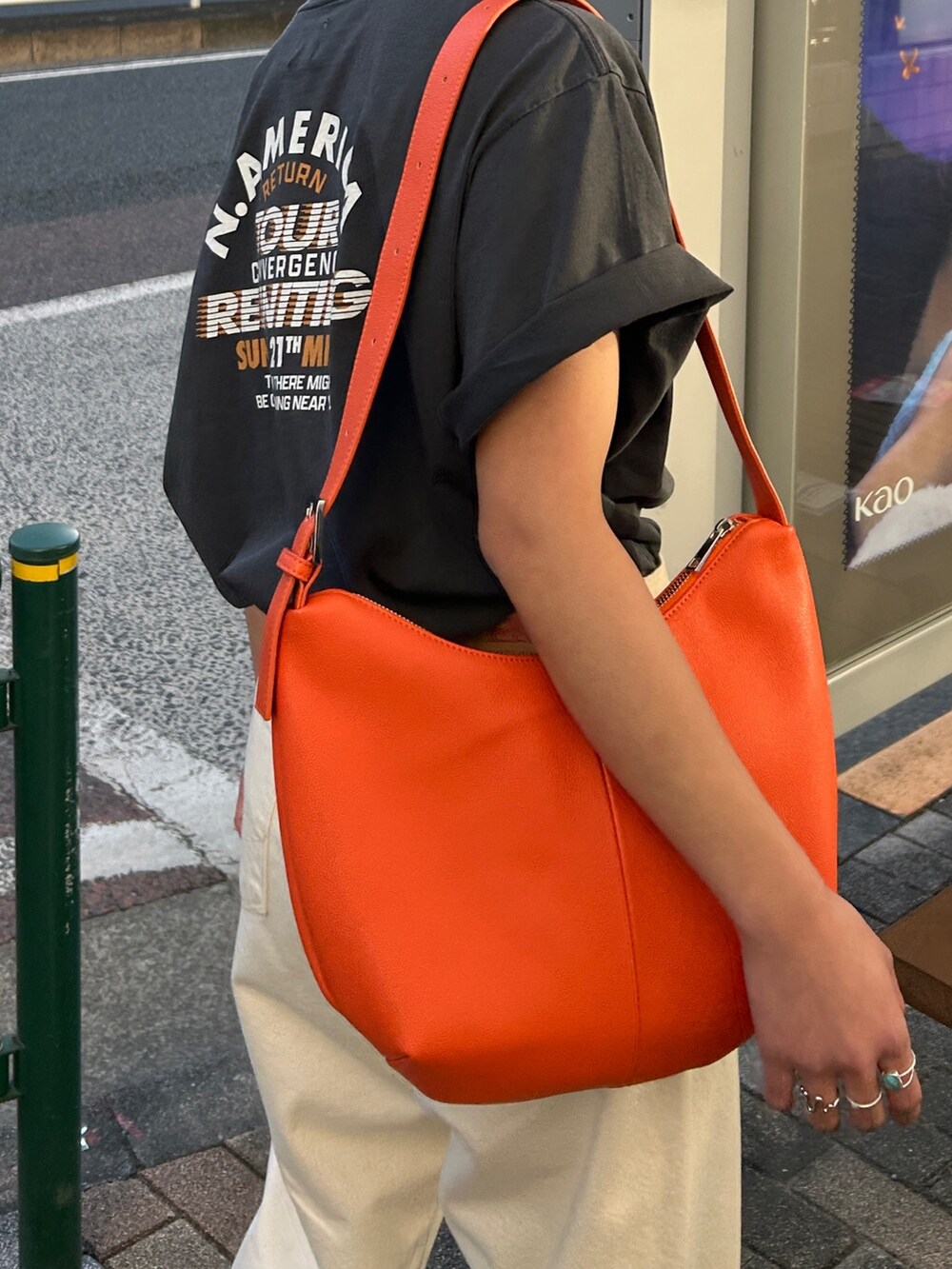 グレー系のTシャツ/カットソー、ホワイト系のデニムパンツ、オレンジ系のショルダーバッグを着用したレディースの春コーディネートの6枚目の写真