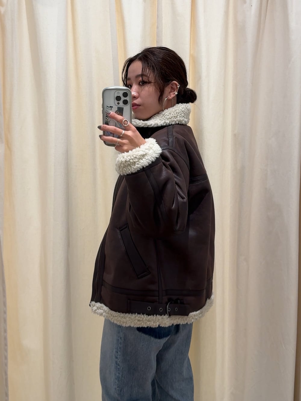 ブルー系のデニムパンツ、ブラウン系のブルゾン、ホワイト系のニット/セーターを着用したレディースの秋コーディネートの8枚目の写真