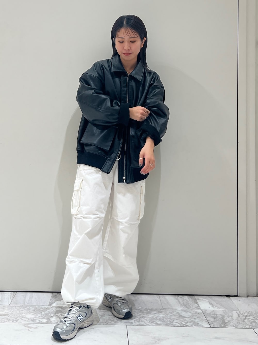 グレー系のニット/セーター、ホワイト系のカーゴパンツ、ブラック系のブルゾンを着用したレディースの秋コーディネートの4枚目の写真