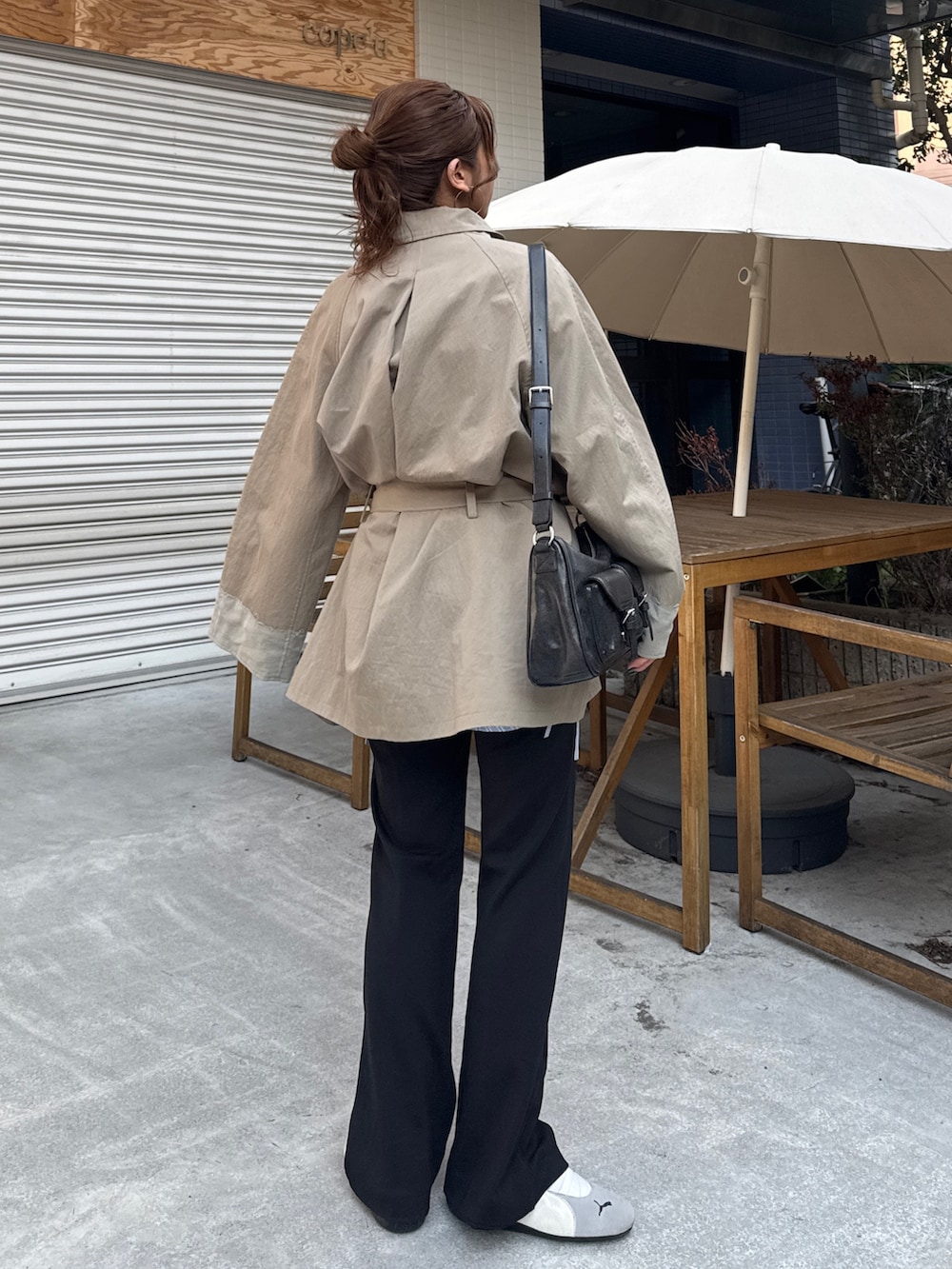 グリーン系のトレンチコート、ブラック系のその他パンツを着用したレディースの冬コーディネートの4枚目の写真