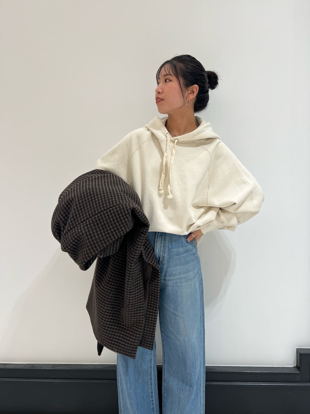 ホワイト系のパーカー、ブルー系のデニムパンツ、ベージュ系のブーツを着用したレディースの冬コーディネートの2枚目の写真