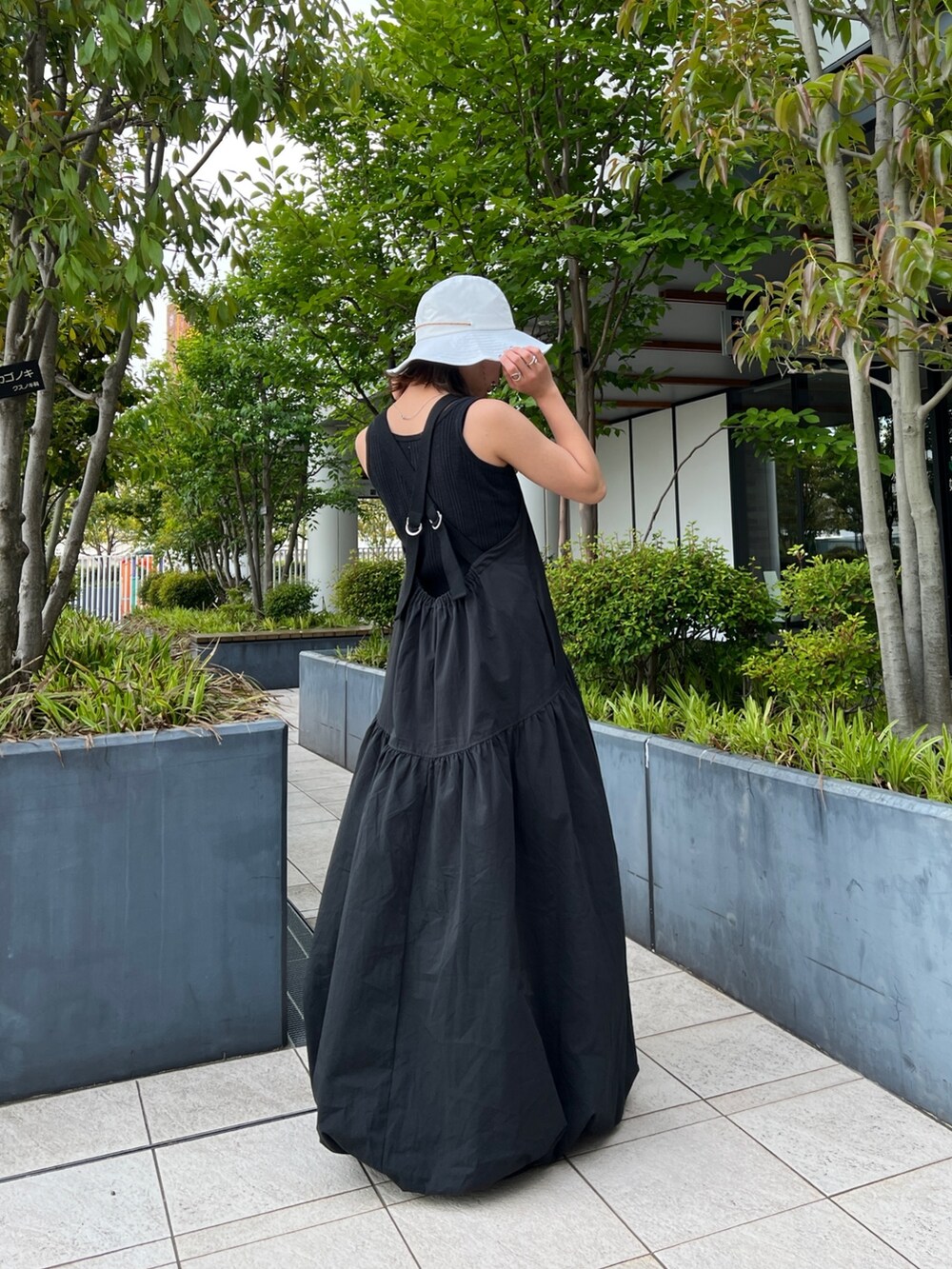 ブラック系のワンピース、グレー系のタンクトップ、ブラック系のサンダルを着用したレディースの春コーディネートの4枚目の写真