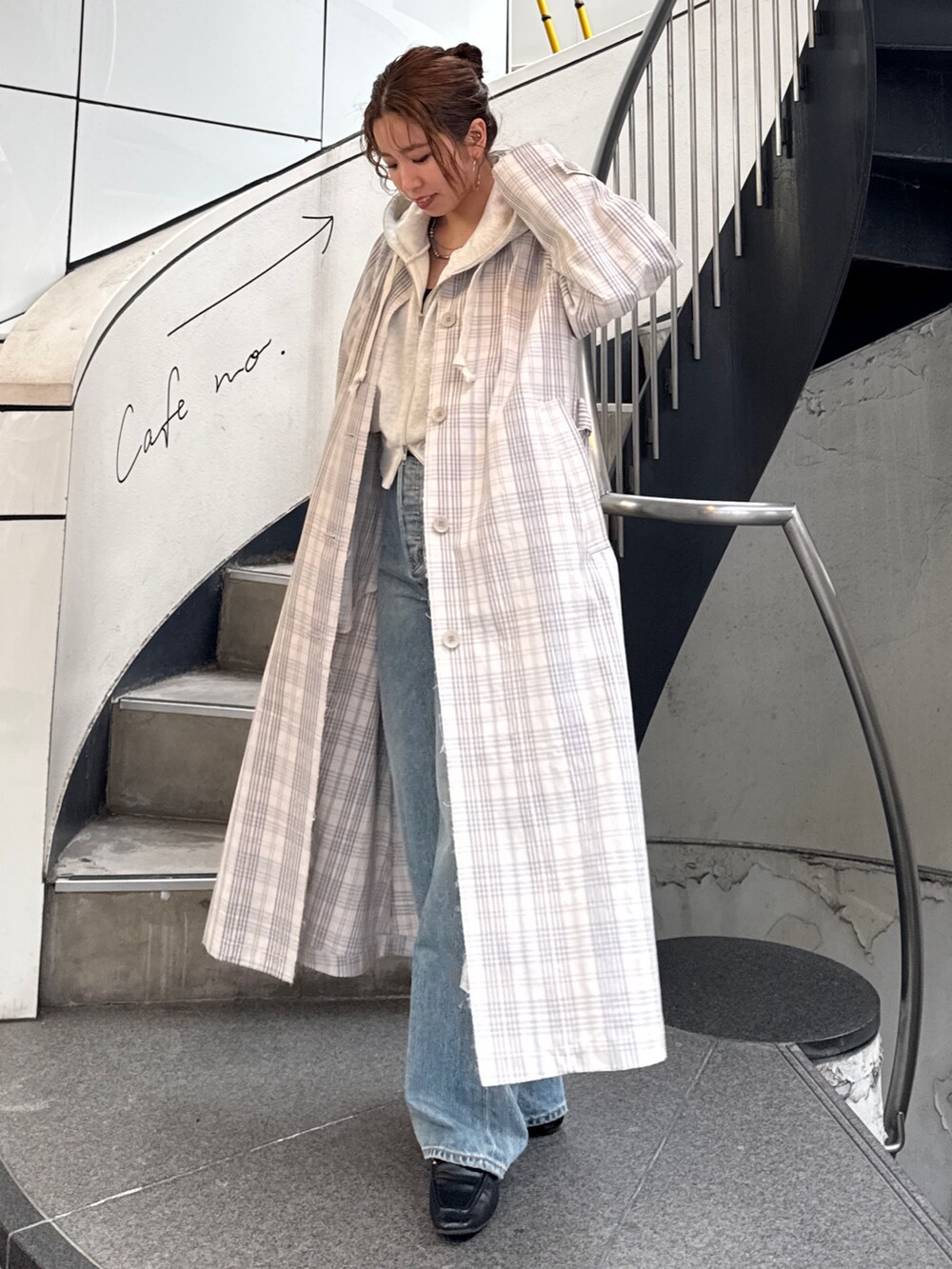 その他のステンカラーコート、ブラック系のボストンバッグ、ホワイト系のパーカーを着用したレディースの冬コーディネートの6枚目の写真