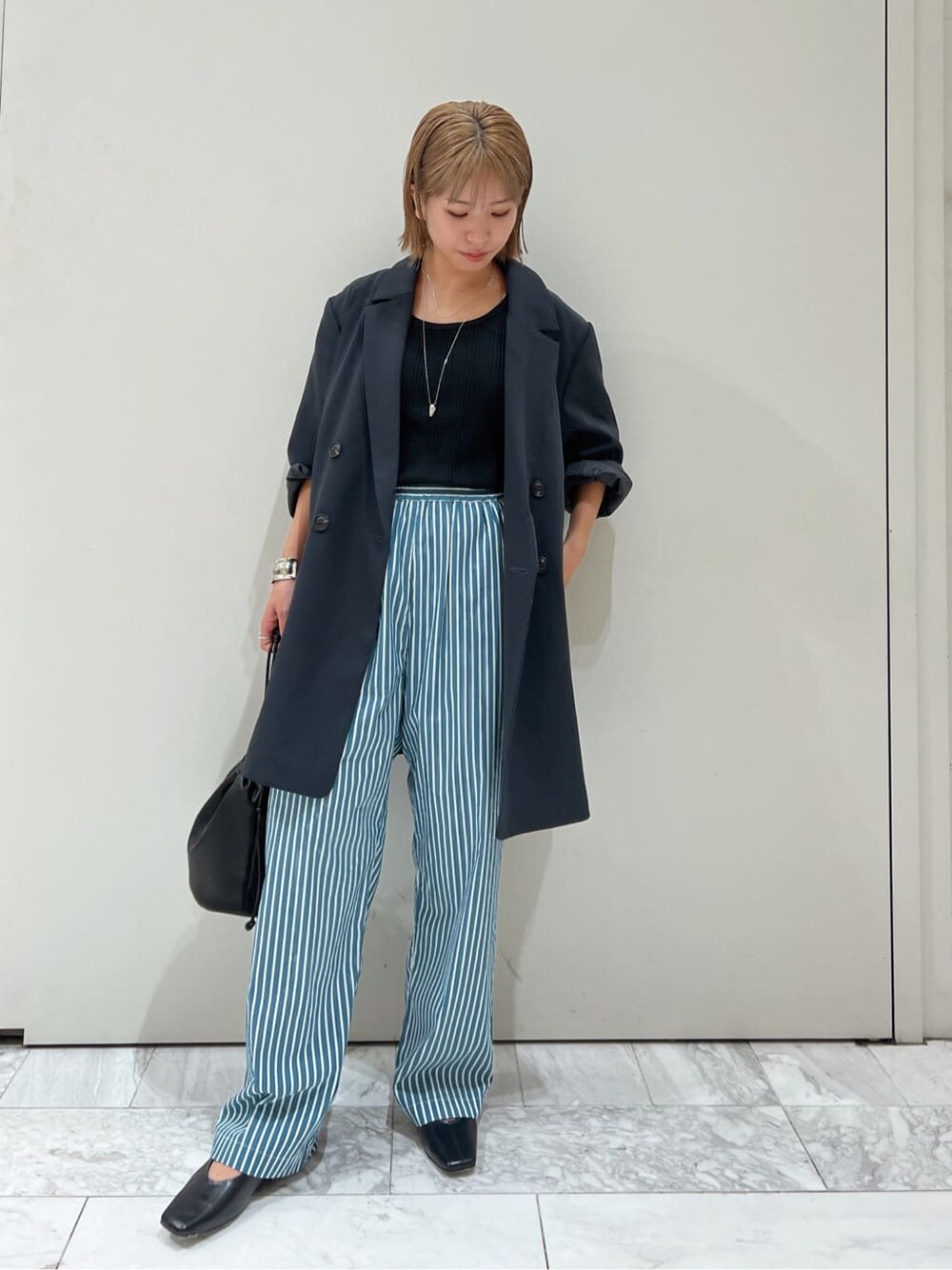 グリーン系のその他パンツ、ブラック系のハンドバッグ、グレー系のテーラードジャケットを着用したレディースの夏コーディネートの2枚目の写真