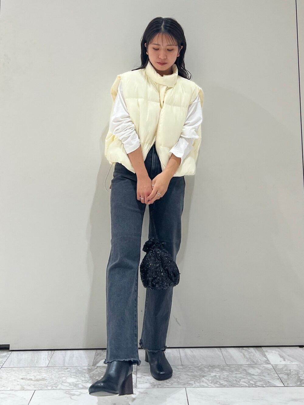 ブラック系のブーツ、ホワイト系のTシャツ/カットソー、ブラック系のデニムパンツを着用したレディースの秋コーディネートの4枚目の写真