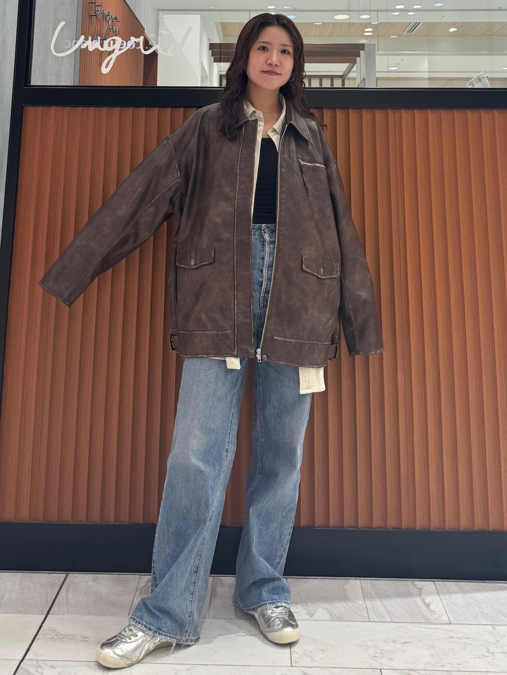 ブラウン系のブルゾン、ホワイト系のシャツ/ブラウス、ブルー系のデニムパンツを着用したレディースの秋コーディネートの6枚目の写真