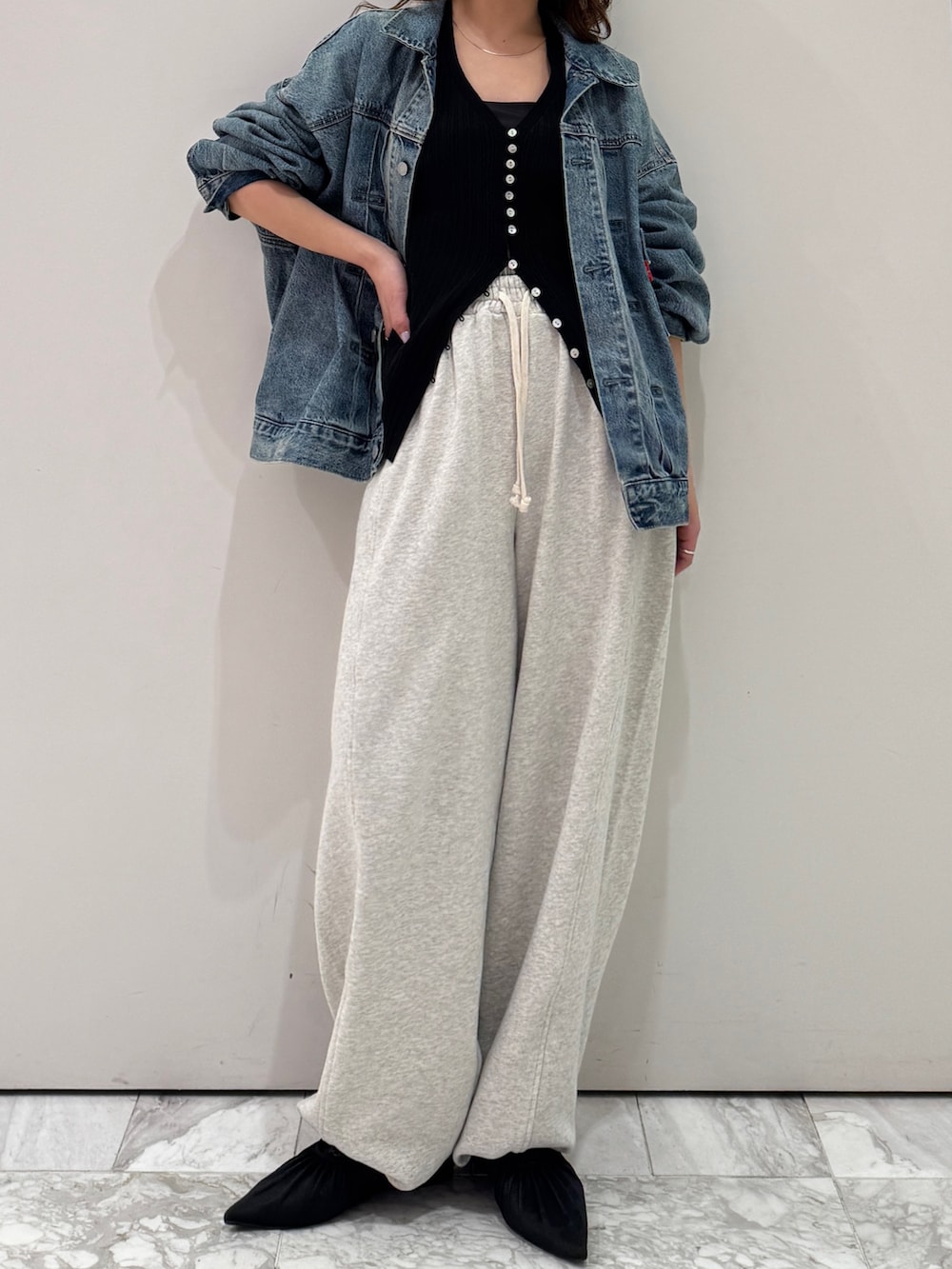 ブルー系のデニムジャケット、ブラック系のカーディガン/ボレロ、ホワイト系のスウェットパンツを着用したレディースの冬コーディネートの6枚目の写真