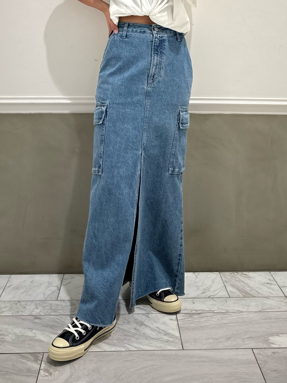 ブルー系のデニムスカート、ホワイト系のTシャツ/カットソー、ブルー系のスニーカーを着用したレディースの春コーディネートの6枚目の写真