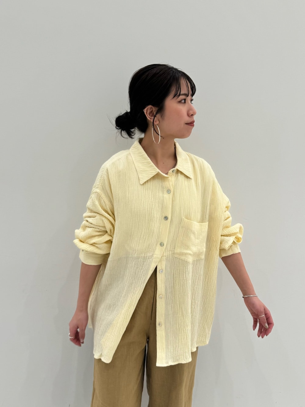 ベージュ系のその他パンツ、ホワイト系のキャミソール、イエロー系のシャツ/ブラウスを着用したレディースの春コーディネートの7枚目の写真