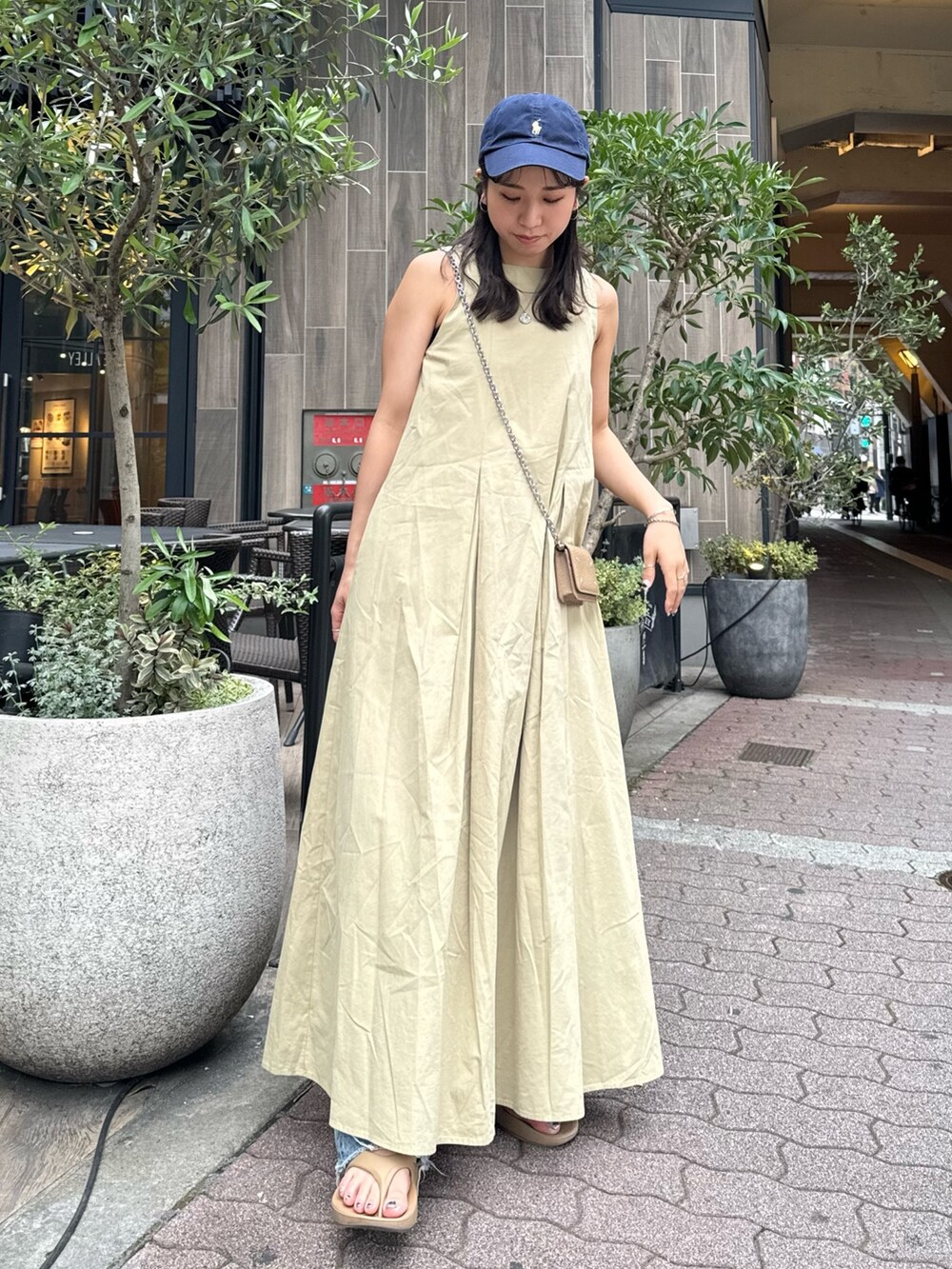 ベージュ系のワンピース、ブルー系のデニムパンツを着用したレディースの春コーディネートの4枚目の写真