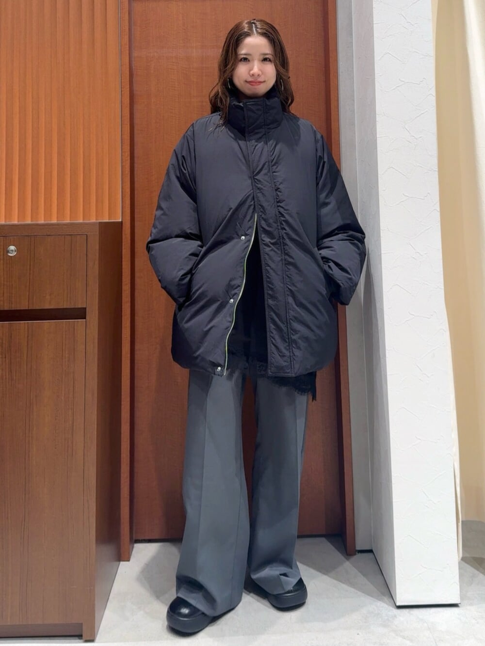 ブラック系のダウンジャケット/コート、グレー系のその他パンツ、ブラック系のキャミソールを着用したレディースの冬コーディネートの5枚目の写真