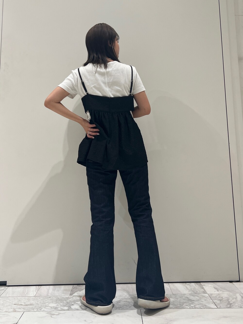 ブルー系のデニムパンツ、ブラック系のキャミソール、ホワイト系のTシャツ/カットソーを着用したレディースの夏コーディネートの5枚目の写真