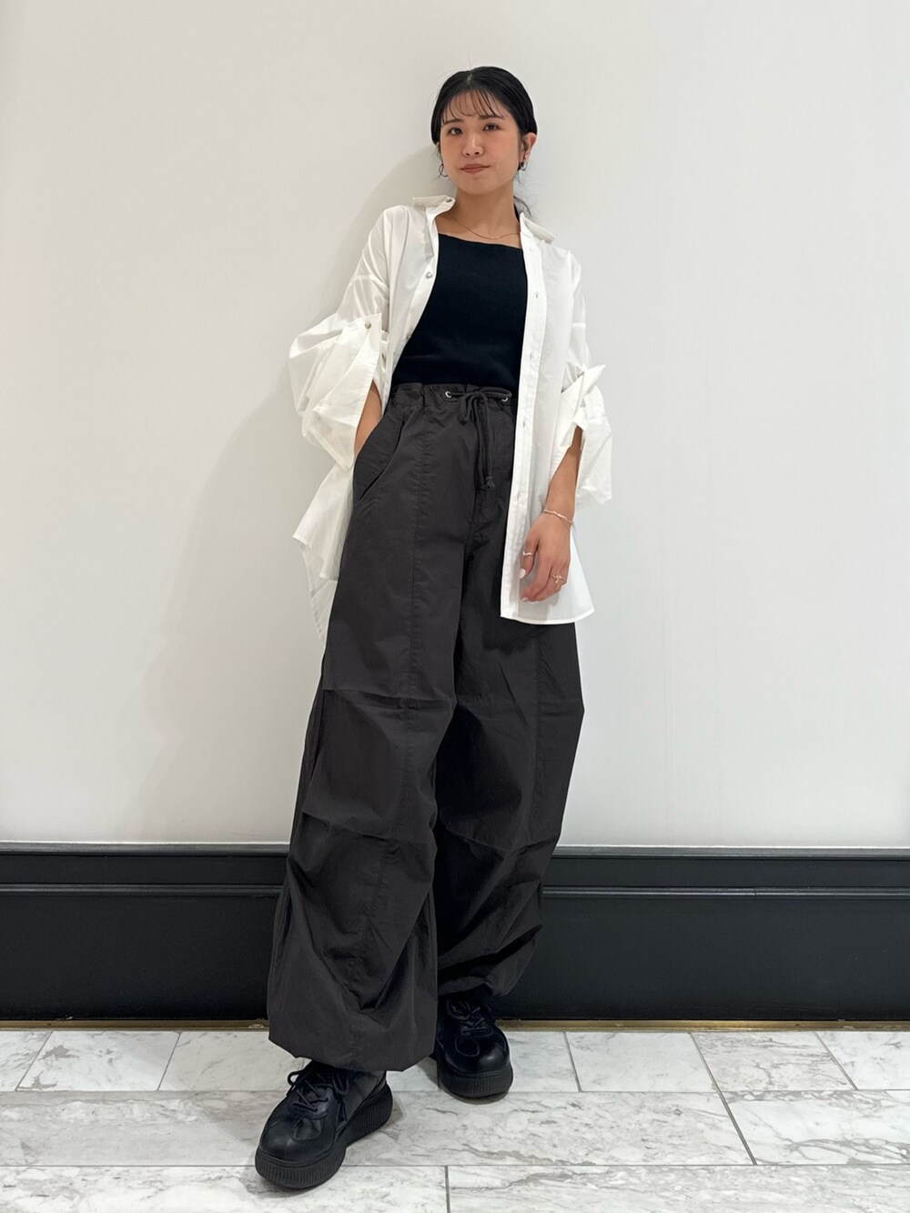 ホワイト系のシャツ/ブラウス、グレー系のその他パンツ、ブラック系のキャミソールを着用したレディースの冬コーディネートの2枚目の写真