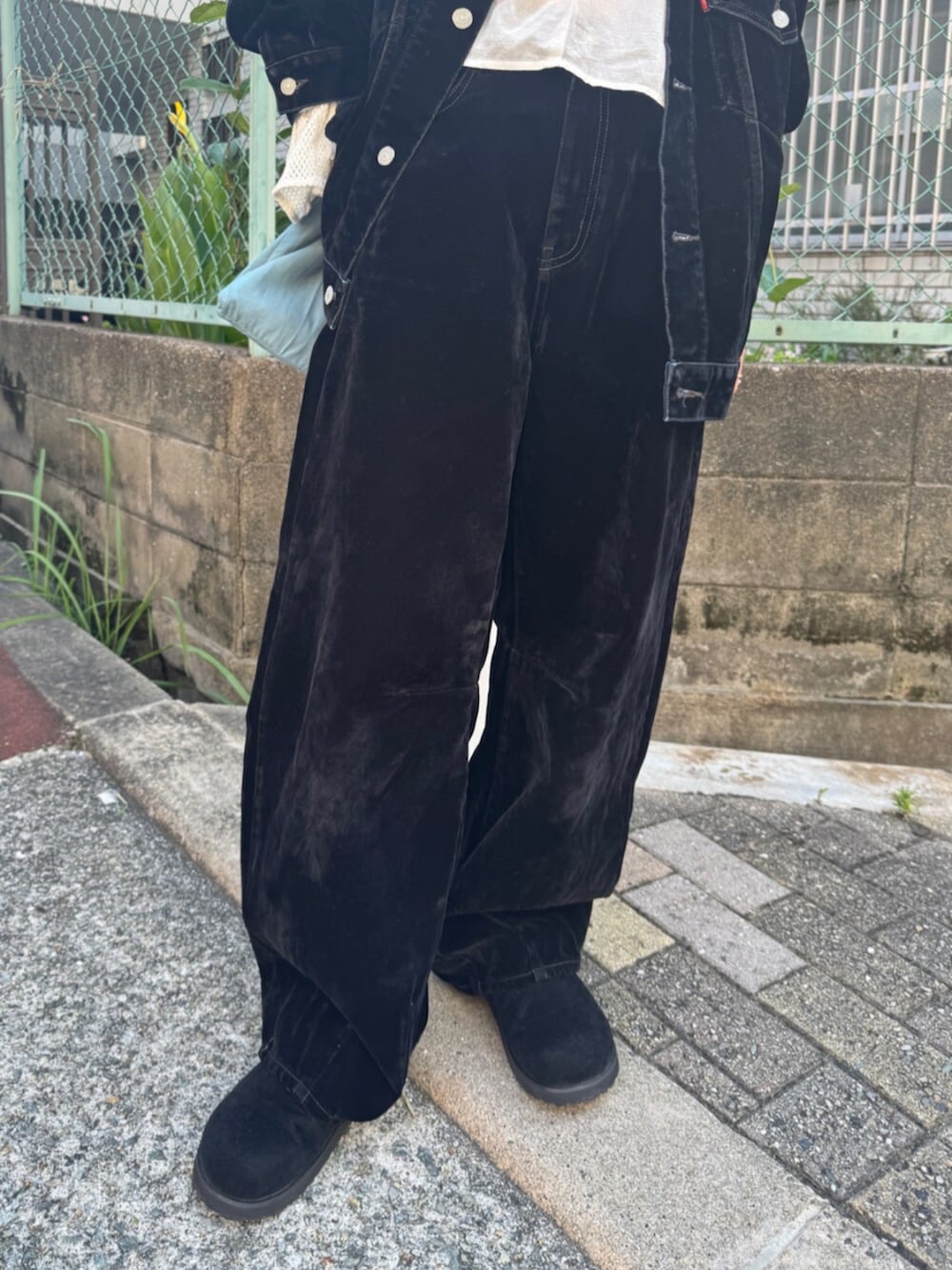 ブラック系のスリッポン、ブラック系のデニムパンツ、ブルー系のトートバッグを着用したレディースの夏コーディネートの8枚目の写真