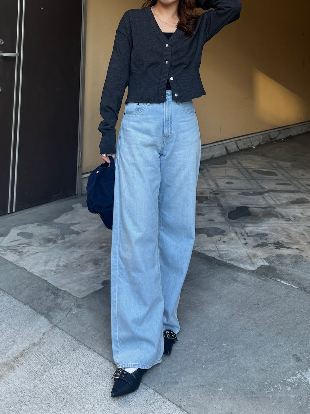 グレー系のカーディガン/ボレロ、ブルー系のデニムパンツを着用したレディースの春コーディネートの2枚目の写真