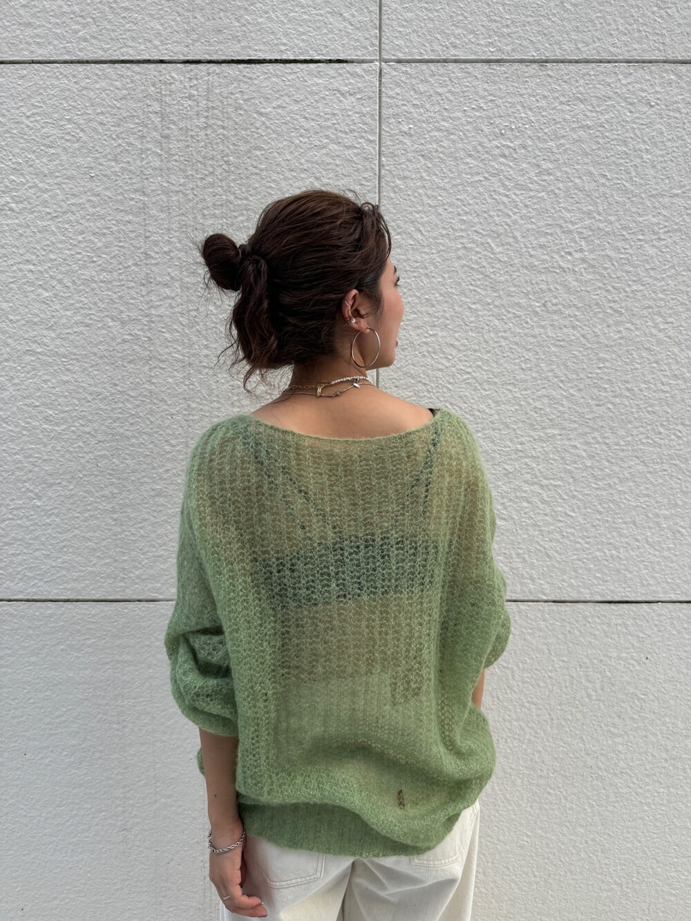 ホワイト系のデニムパンツ、グリーン系のニット/セーターを着用したレディースの秋コーディネートの7枚目の写真