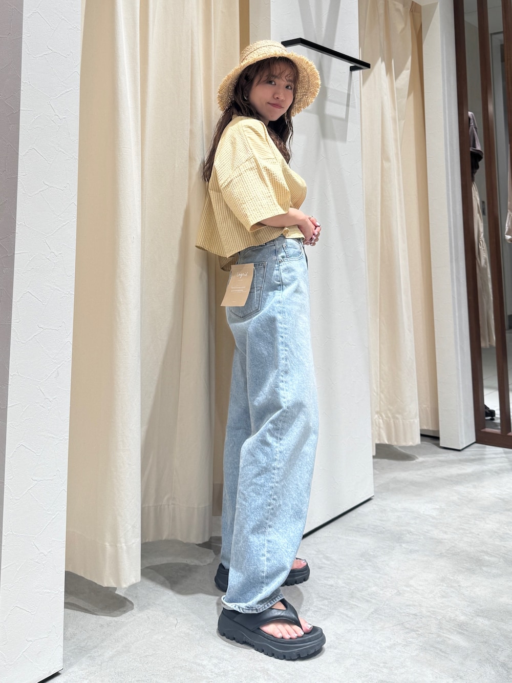 イエロー系のシャツ/ブラウス、ブルー系のデニムパンツ、ベージュ系のハットを着用したレディースの春コーディネートの4枚目の写真