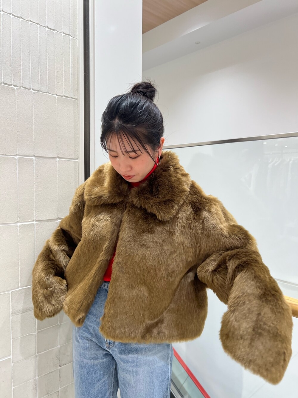 ブルー系のデニムパンツ、ブラウン系のブルゾン、レッド系のニット/セーターを着用したレディースの冬コーディネートの10枚目の写真