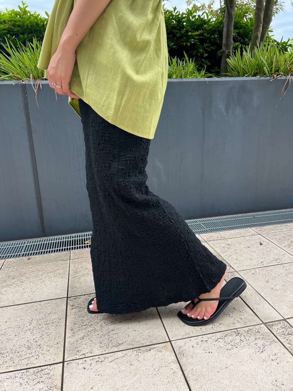 グリーン系のシャツ/ブラウス、ブラック系のスカート、ブラック系のサンダルを着用したレディースの夏コーディネートの7枚目の写真