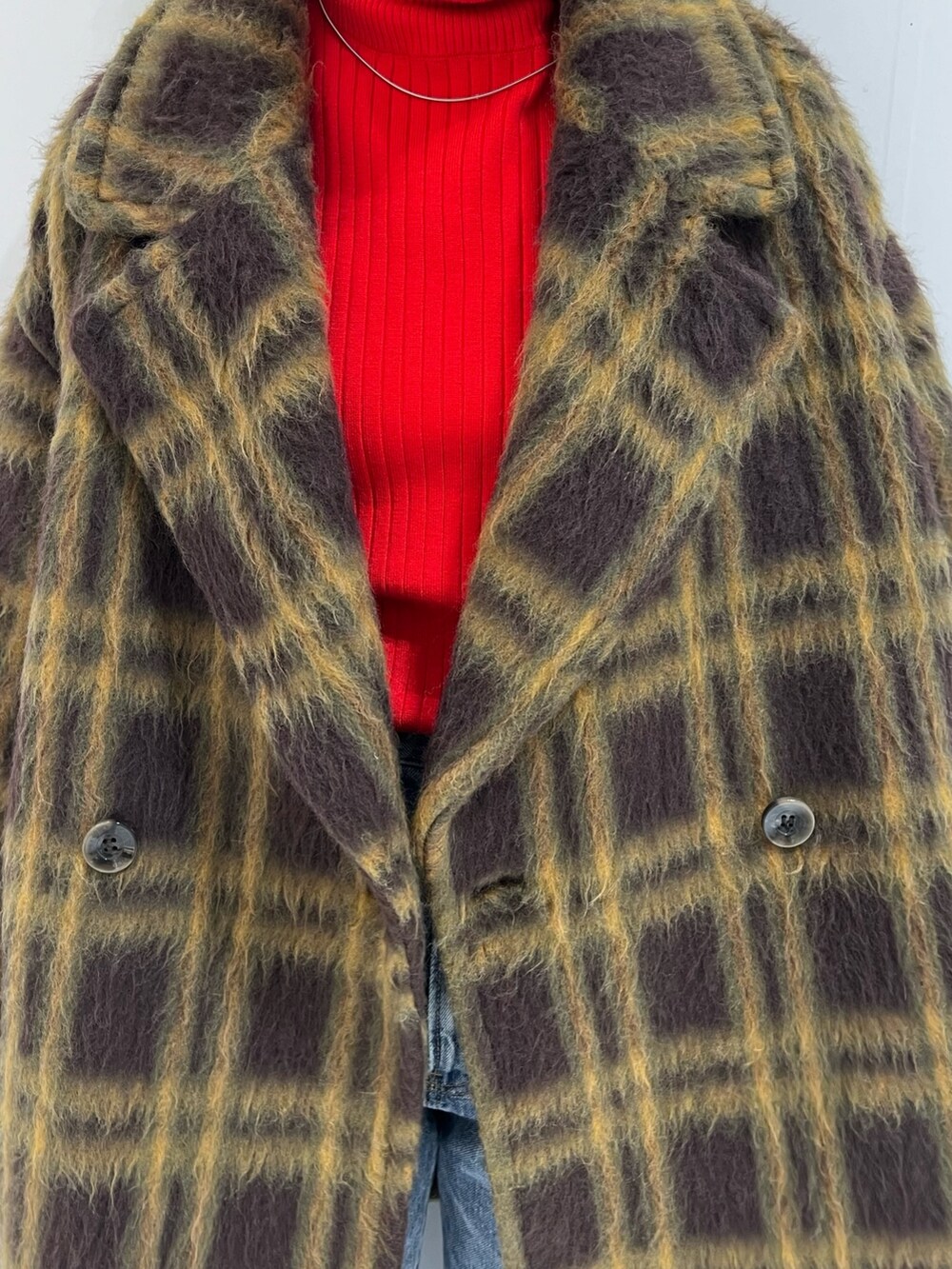 レッド系のニット/セーター、ホワイト系のハンドバッグ、ブルー系のデニムパンツを着用したレディースの冬コーディネートの8枚目の写真