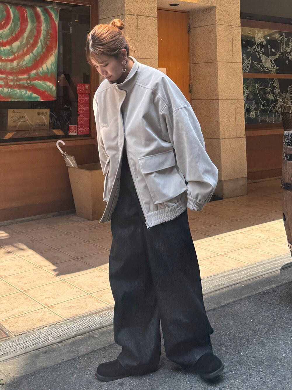 ベージュ系のブルゾン、ブラック系のデニムパンツ、ブラック系のスリッポンを着用したレディースの秋コーディネートの5枚目の写真