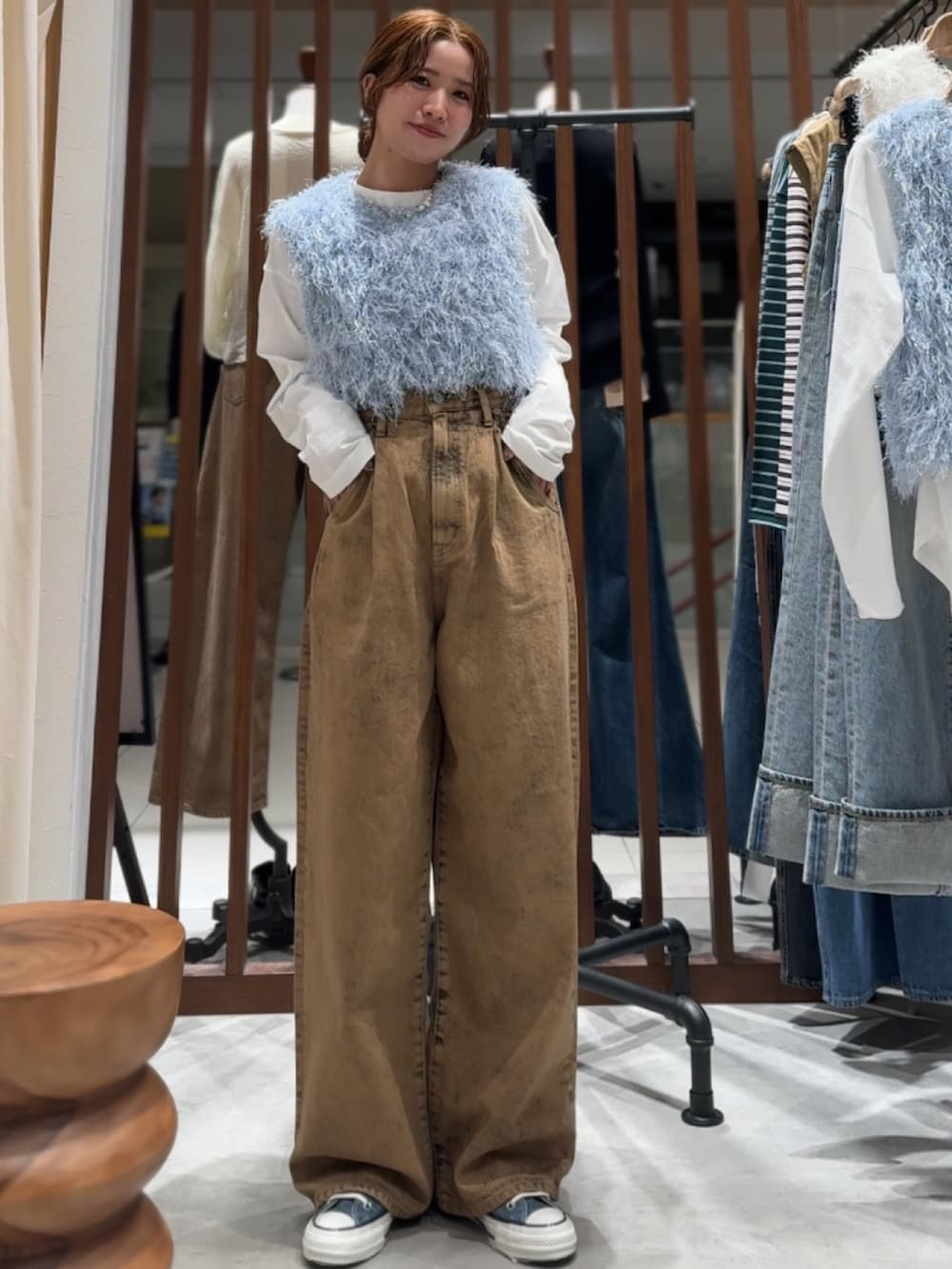 ブラウン系のデニムパンツ、ブルー系のニット/セーター、ホワイト系のTシャツ/カットソーを着用したレディースの春コーディネートの6枚目の写真