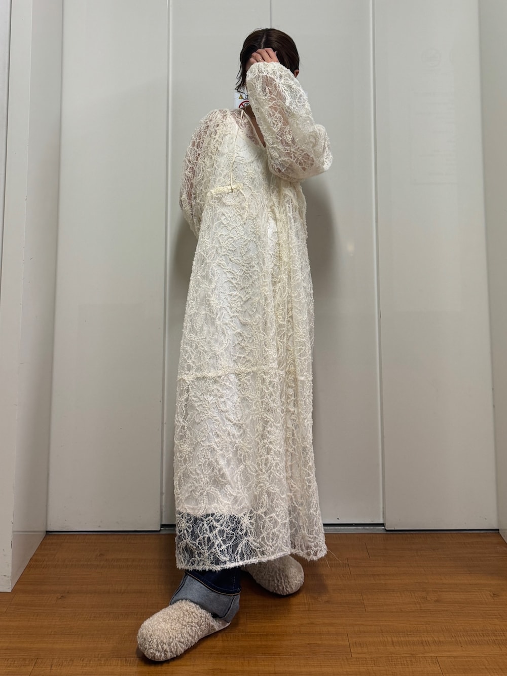 ベージュ系のブルゾン、ホワイト系のワンピース、ブルー系のデニムパンツを着用したレディースの冬コーディネートの8枚目の写真