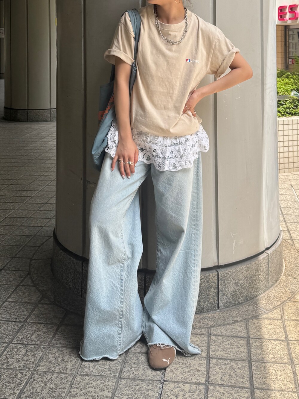 ブルー系のデニムパンツ、ブルー系のトートバッグ、ホワイト系のシャツ/ブラウスを着用したレディースの夏コーディネートの4枚目の写真